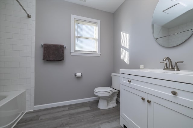 full bathroom with shower / bath combination, toilet, vanity, wood finished floors, and baseboards