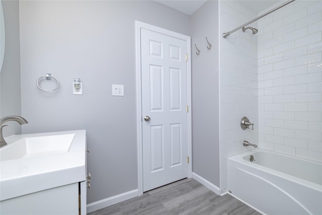 full bathroom featuring tub / shower combination, vanity, baseboards, and wood finished floors