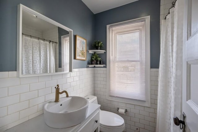 bathroom featuring tile walls, vanity, and toilet