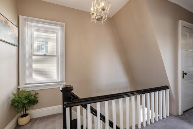 stairs featuring a notable chandelier and carpet flooring