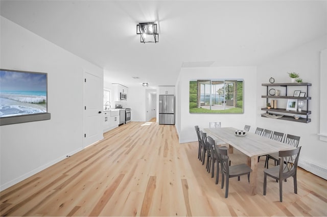 dining room with sink and light wood-type flooring