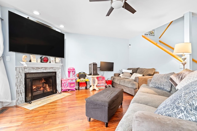 living room with a premium fireplace, a ceiling fan, wood finished floors, and recessed lighting