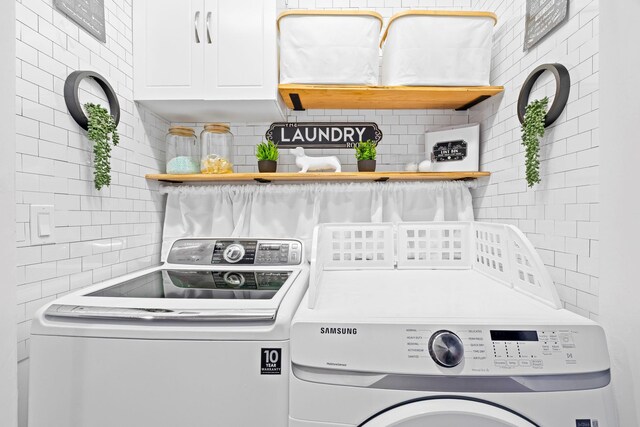 laundry room featuring washing machine and dryer and cabinet space