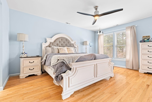 bedroom with a ceiling fan, baseboards, visible vents, and light wood finished floors