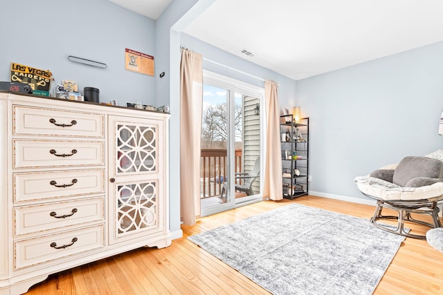 sitting room featuring baseboards, visible vents, and light wood finished floors