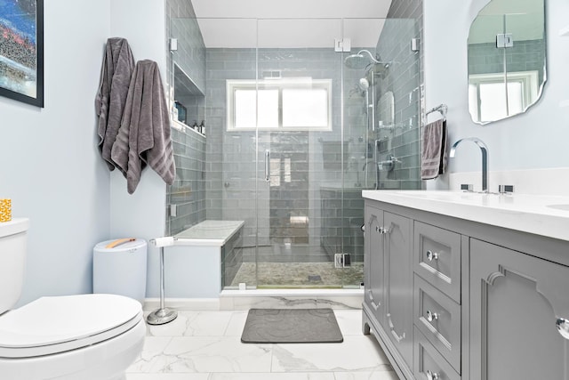 full bath featuring toilet, marble finish floor, a shower stall, and vanity