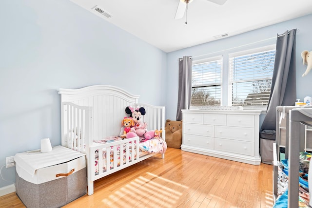 bedroom with light wood-type flooring, visible vents, and a ceiling fan