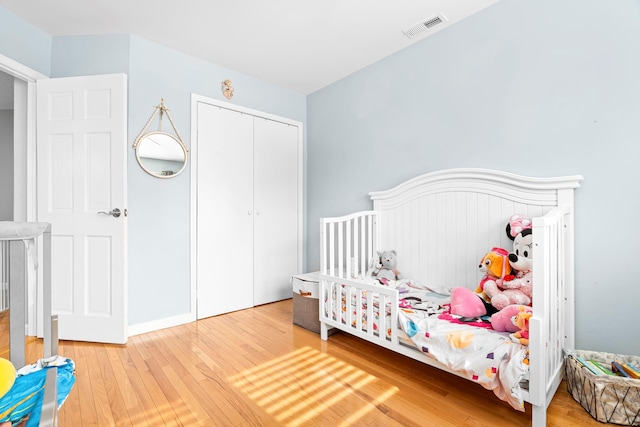 bedroom featuring a closet, visible vents, and wood finished floors