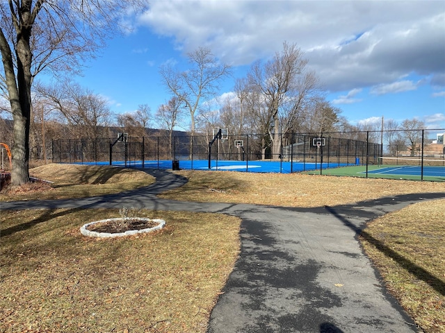 view of swimming pool with a tennis court, community basketball court, and fence