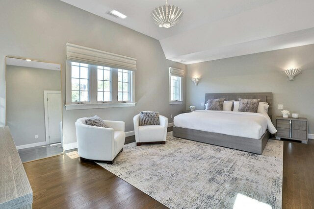 bedroom featuring visible vents, baseboards, lofted ceiling, dark wood-style flooring, and a notable chandelier