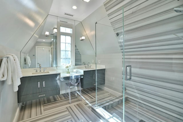 bathroom with double vanity, visible vents, a stall shower, and a sink