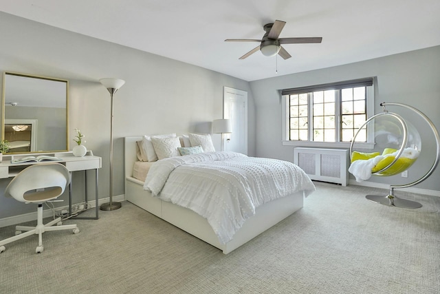 carpeted bedroom featuring a ceiling fan, radiator heating unit, and baseboards