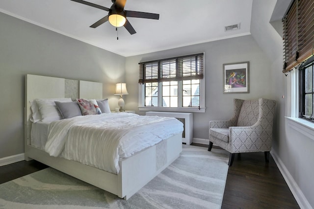 bedroom with visible vents, baseboards, and wood finished floors