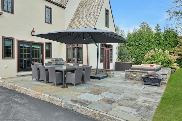 view of patio featuring outdoor dining space, area for grilling, french doors, and an outdoor living space with a fire pit