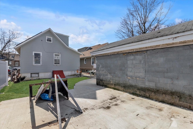 back of property with a lawn and a patio