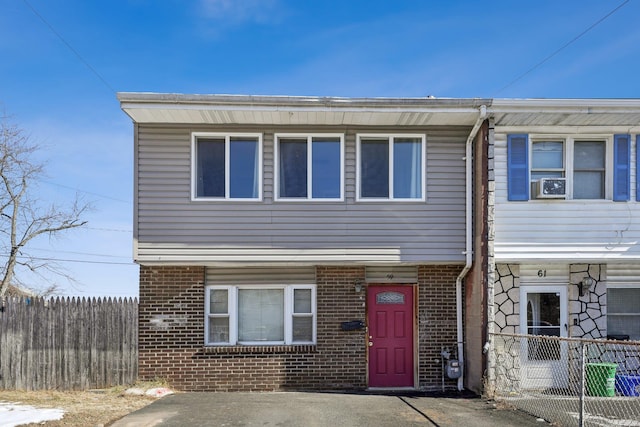 view of front facade featuring fence and brick siding