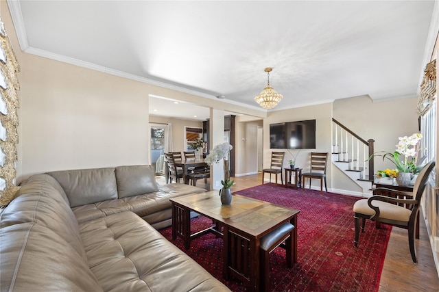 living area featuring baseboards, stairway, wood finished floors, an inviting chandelier, and crown molding