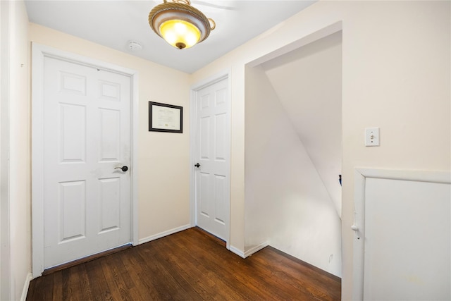 hall with dark wood-style floors and baseboards