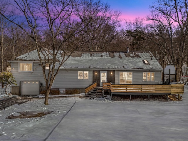 view of front facade featuring an attached garage and a wooden deck