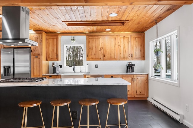 kitchen featuring appliances with stainless steel finishes, island range hood, light countertops, and baseboard heating