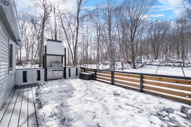 snow covered deck with an outdoor kitchen, fence, and grilling area