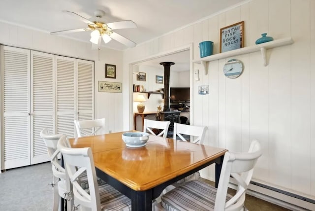 dining room featuring ornamental molding, a wood stove, and ceiling fan