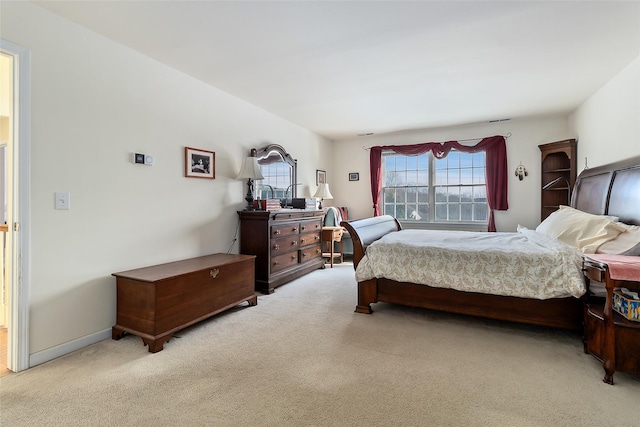 bedroom with baseboards and light colored carpet