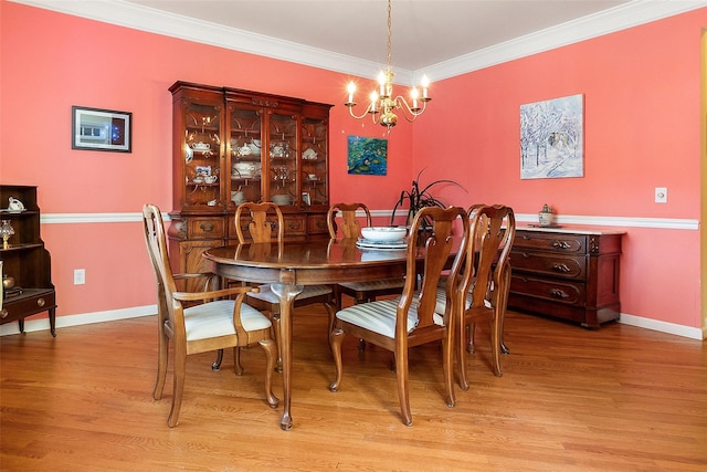 dining area featuring light wood-style flooring, a chandelier, ornamental molding, and baseboards