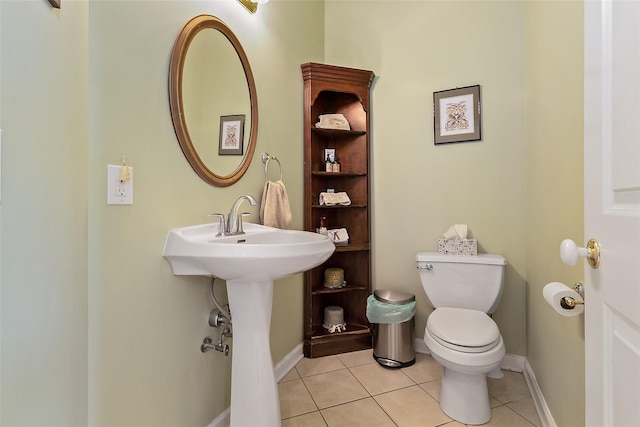 bathroom with tile patterned flooring, toilet, and baseboards