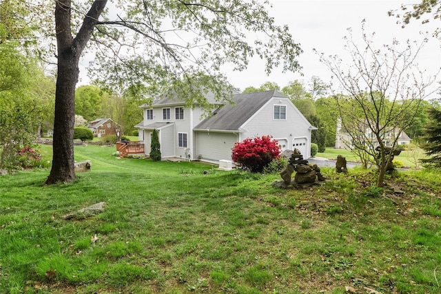 back of house featuring a garage, a yard, and a deck