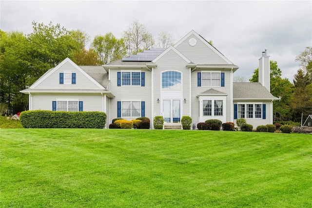28 Teal Ln, Brewster, NY 10509 - colonial-style house with solar panels, a front yard, a chimney, and entry steps