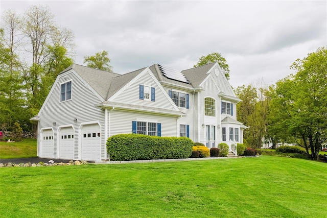 28 Teal Ln, Brewster, NY 10509 - view of front of property with an attached garage, roof mounted solar panels, a front yard, and asphalt driveway