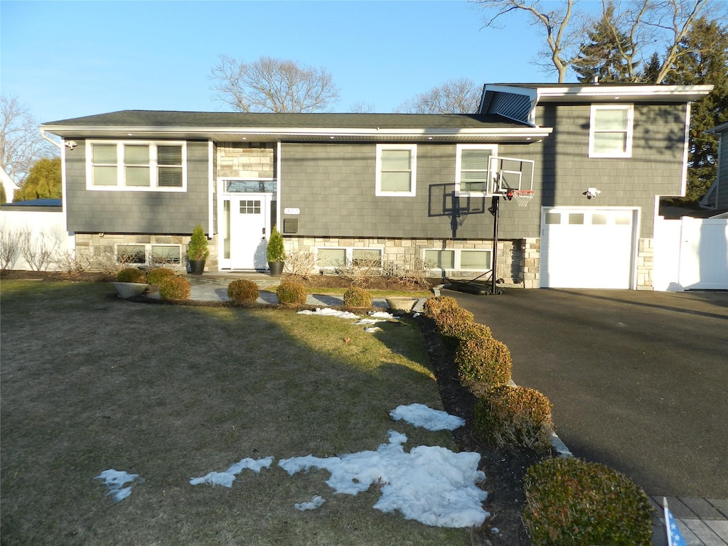 bi-level home with a front yard and a garage