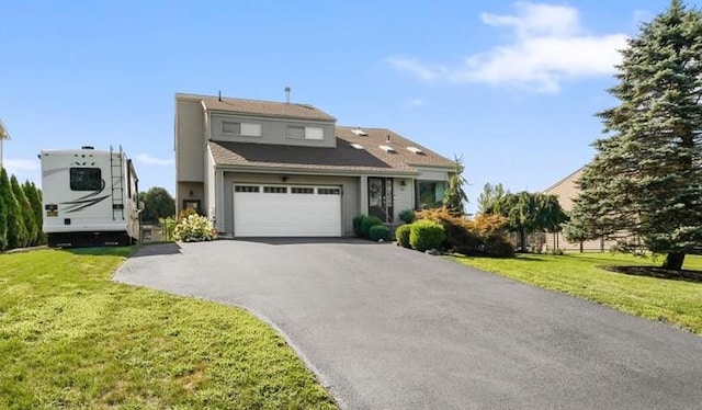 view of front of house featuring a front lawn, an attached garage, and aphalt driveway