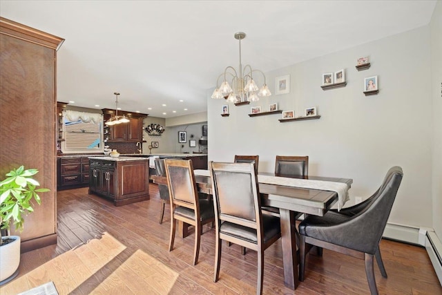 dining space featuring a baseboard radiator, a chandelier, wood finished floors, and recessed lighting