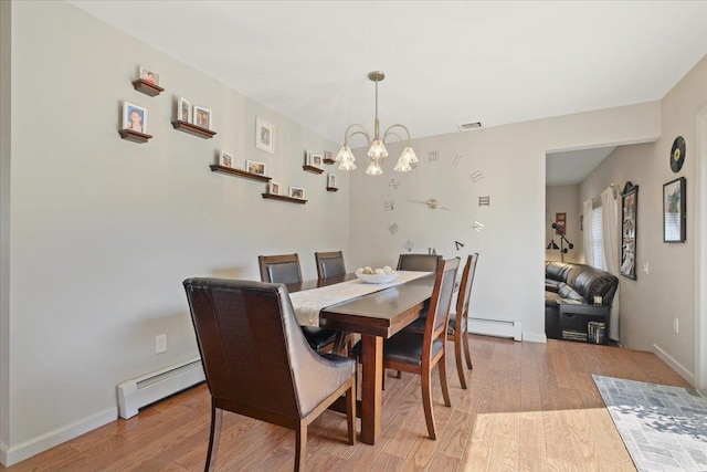 dining area with light wood-style flooring, visible vents, a baseboard heating unit, and a chandelier