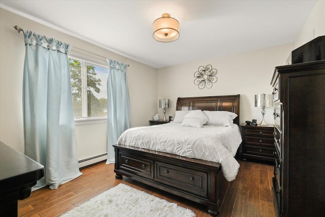 bedroom with baseboard heating and wood finished floors