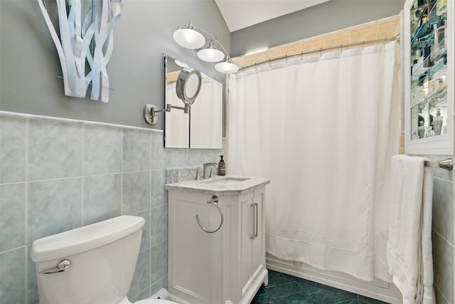 full bath with toilet, tile walls, vanity, and shower / tub combo with curtain