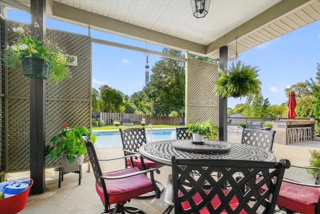 view of patio / terrace with a fenced in pool, fence, and outdoor dry bar