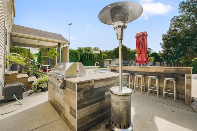 view of patio / terrace featuring an outdoor kitchen, a sink, a bar, and area for grilling