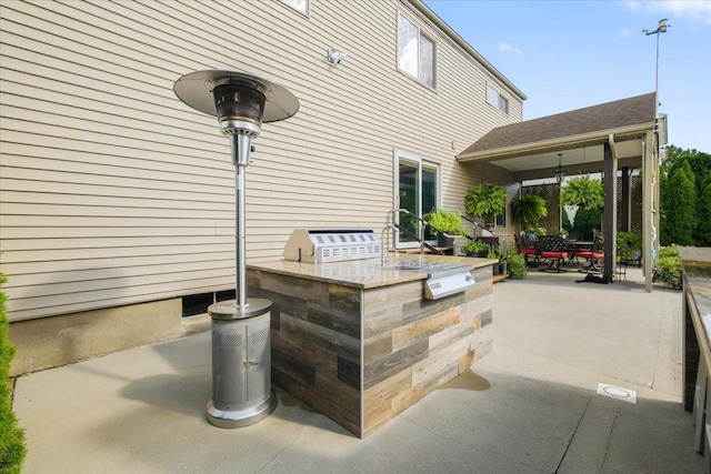 view of patio / terrace featuring exterior kitchen, an outdoor bar, and a grill