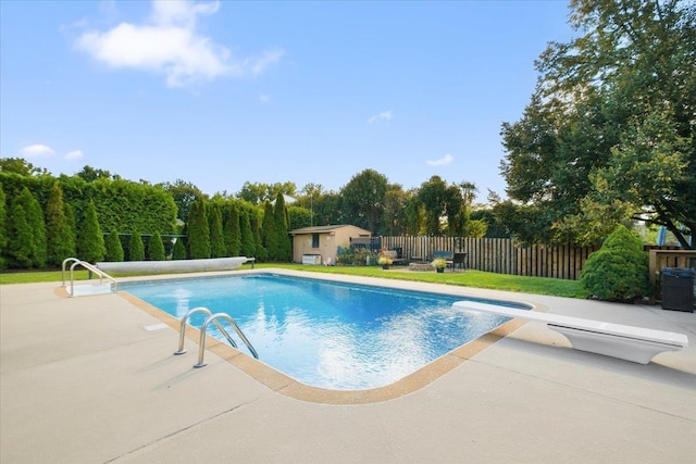 view of pool featuring a fenced backyard, a diving board, a fenced in pool, and a patio