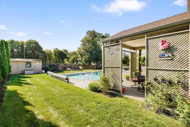 view of pool featuring a fenced in pool, an outbuilding, a storage unit, fence, and a yard