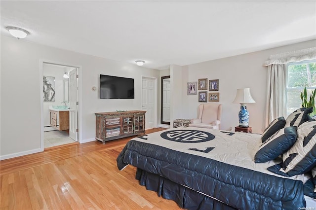 bedroom with hardwood / wood-style flooring and ensuite bathroom