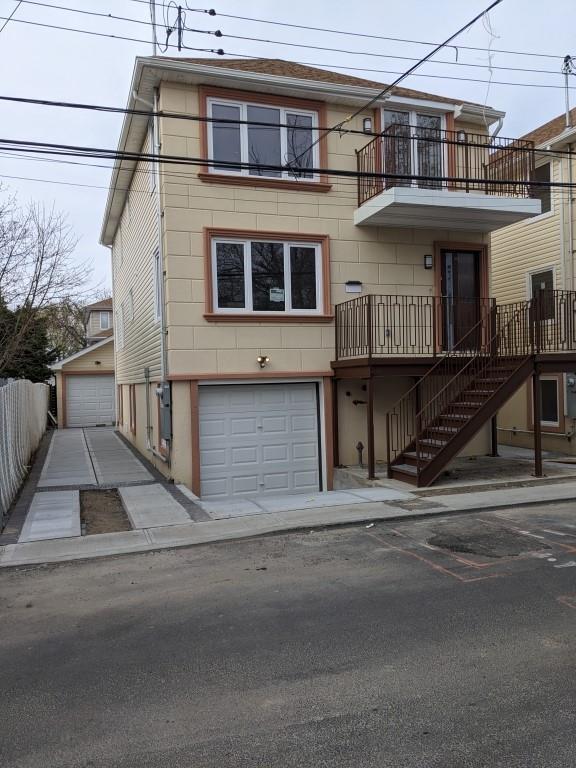 view of front of home featuring a garage and a balcony