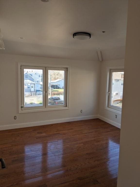 spare room featuring dark hardwood / wood-style floors and a wealth of natural light