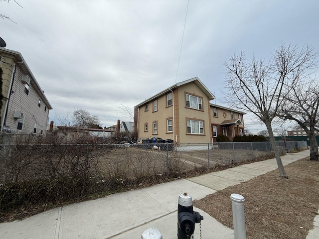 exterior space with a fenced front yard and stucco siding