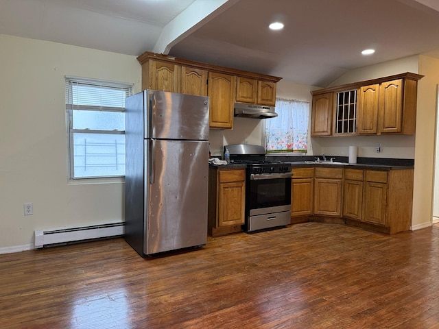 kitchen with stainless steel appliances, dark countertops, under cabinet range hood, and baseboard heating