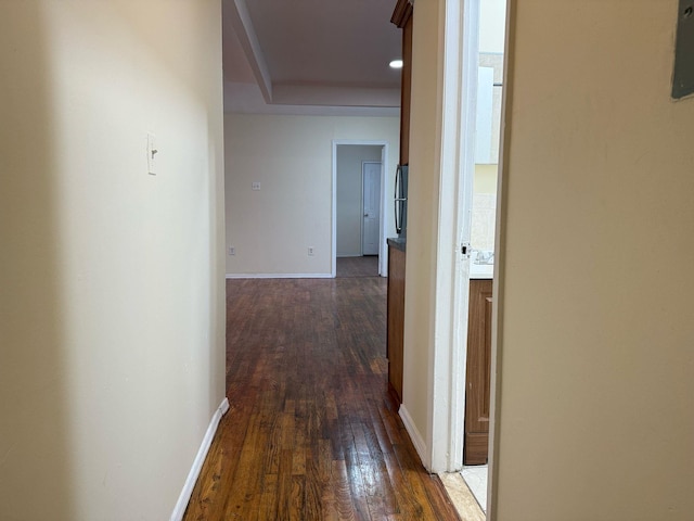 hallway featuring baseboards and dark wood-style flooring