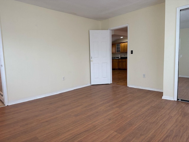 unfurnished bedroom featuring dark wood-style flooring and baseboards